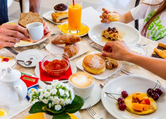Hearty breakfast with pastries, fruit, coffee, and orange juice.