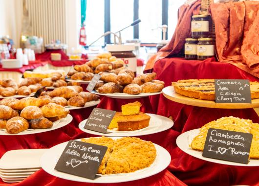Dessert buffet with croissants and various cakes.