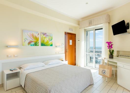 Bright room with sea view, floral decor, and TV.