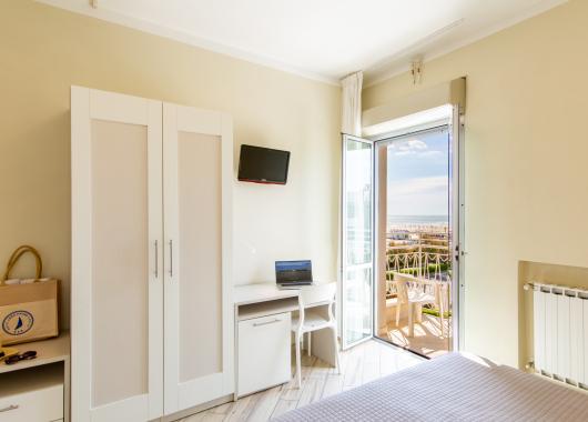 Bright room with sea view, wardrobe, and desk.