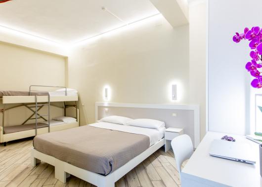 Modern room with double and bunk beds, decorated with orchids.