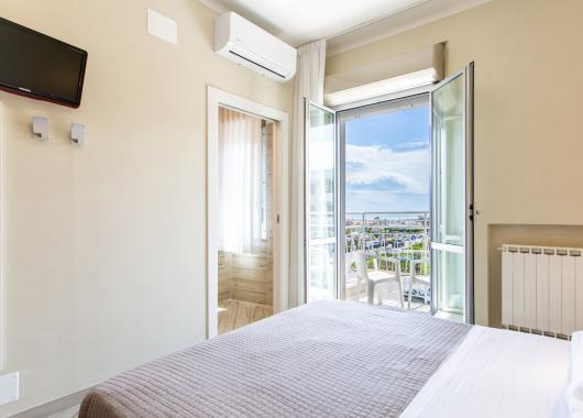 Bright room with sea view, TV, and air conditioning.
