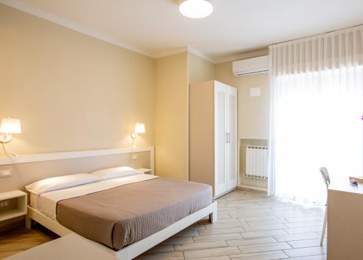 Modern room with bed, wardrobe, and flowers.