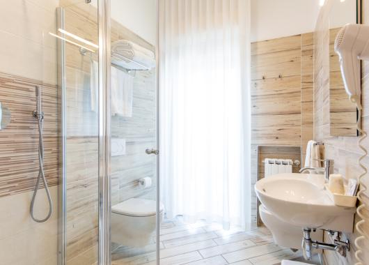 Modern bathroom with shower, sink, and hairdryer.