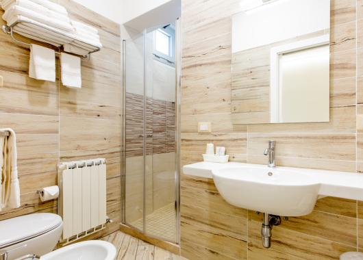 Modern bathroom with shower, sink, and towels.
