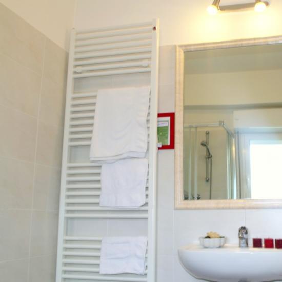 Bagno moderno con specchio, lavabo e asciugamani.