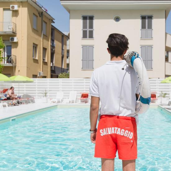 Bagnino in piscina con salvagente, pronto per il salvataggio.