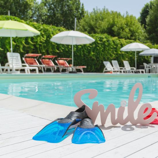 Piscina estiva con pinne e scritta 'Smile'.