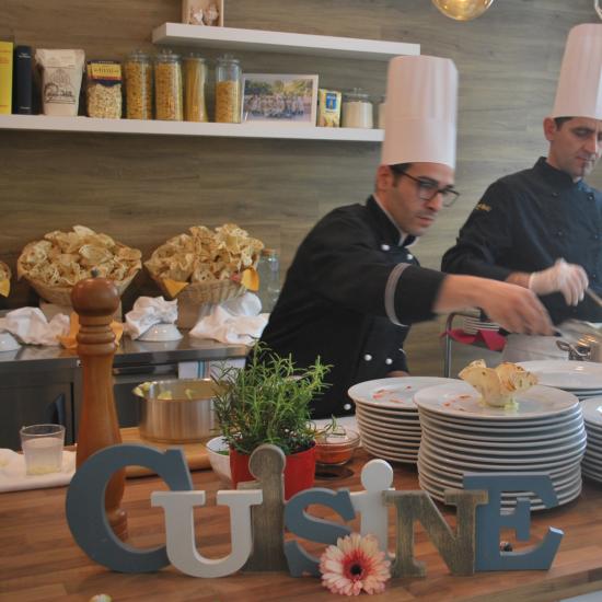 Chef preparano piatti in cucina con decorazioni e ingredienti.