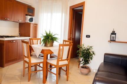 Modern kitchen with wooden table and decorative plants.