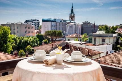 Breakfast table overlooking rooftops and a bell tower.