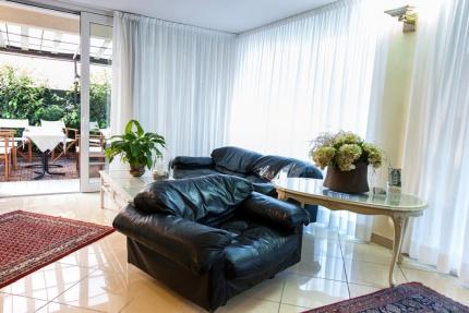 Bright living room with leather sofa, plants, and outdoor table.