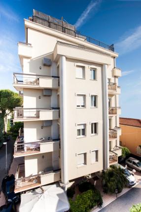 Modern residential building with balconies and clear sky.