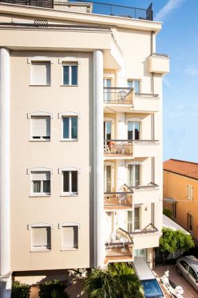 Residential building with balconies, clear sky.