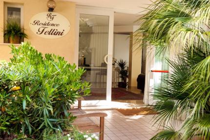 Entrance of Residence Fellini with plants and glass door.