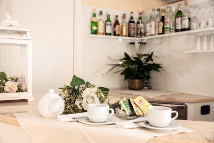 Tea table with cups, teapot, and floral decorations.