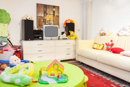 Living room with toys, sofa, and retro TV.