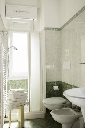 Modern bathroom with shower, sink, and white towels.