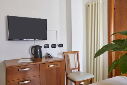 Room with TV, kettle, chair, and radiator.