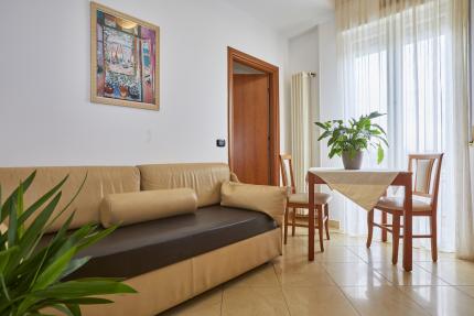 Bright living room with beige sofa and table with plant.