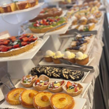 Assorted dessert buffet, including fruit tarts and pastries.