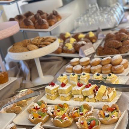 An assorted dessert buffet with pastries, cookies, and fruit cakes.