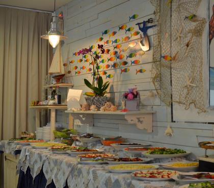 Buffet con decorazioni marine e piatti variopinti.