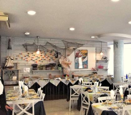 Ristorante elegante con decorazioni marine e tavoli apparecchiati.