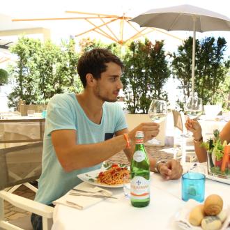 Due persone brindano al ristorante all'aperto.