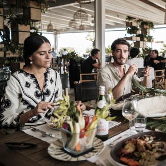 Persone che pranzano in un ristorante elegante e luminoso.