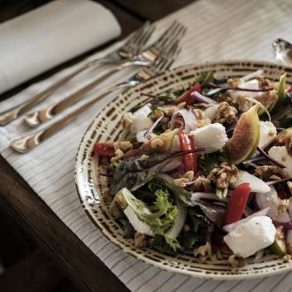 Insalata fresca con formaggio, fichi, noci e pomodori.