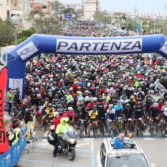 Inizio di una gara ciclistica con molti partecipanti alla partenza.