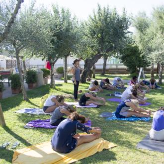 Lezione di yoga all'aperto in un parco soleggiato.