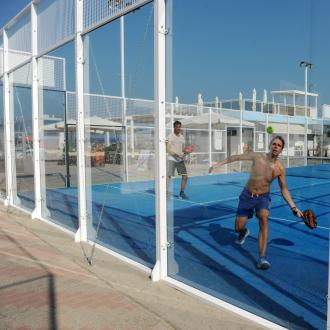 Due persone giocano a padel su un campo all'aperto.