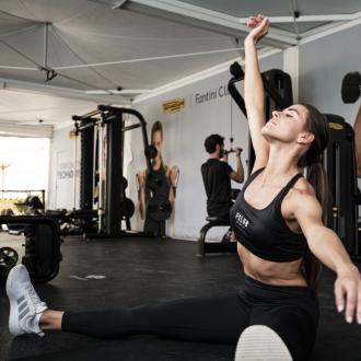 Donna si allena in palestra con attrezzi Technogym.