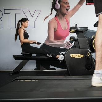 Persone si allenano in palestra con attrezzature Technogym.