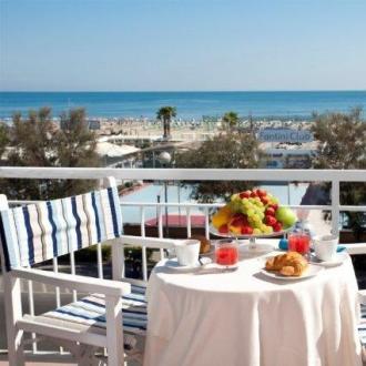 Colazione con vista mare, tavolo apparecchiato su terrazza.