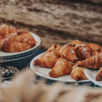 Croissant su piatti bianchi, spolverati di zucchero a velo.