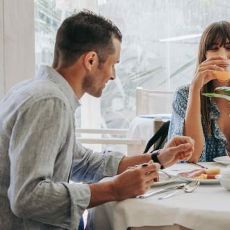 Due persone fanno colazione insieme in un ristorante luminoso.