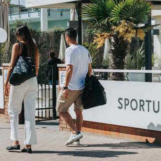 Persone camminano verso l'ingresso del Sportur Club Hotel.