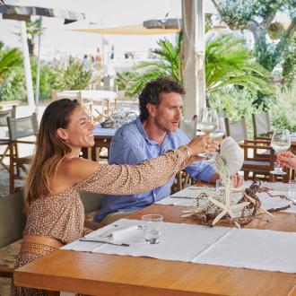 Tre persone brindano in un ristorante all'aperto.