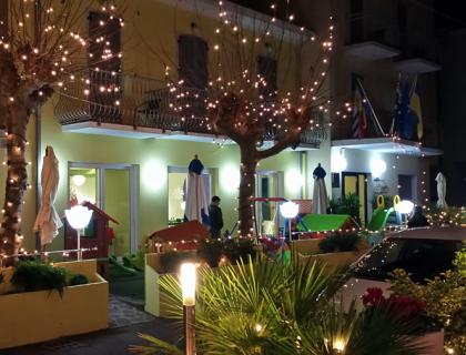 Un ristorante con luci natalizie e decorazioni all'aperto di notte.