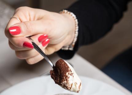 Tiramisu im Glas, Löffel in der Hand.