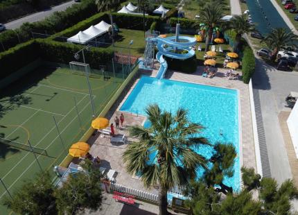 Pool mit Rutsche und Sportplatz im Freien.