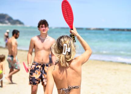 Zwei Personen spielen Strandtennis am Strand.