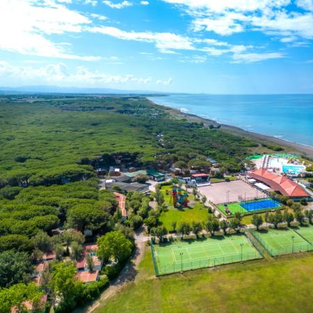 Aerial view of a coastal resort with pools and sports fields.