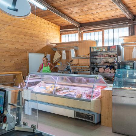 Deli with fresh products and vegetables, run by a person.