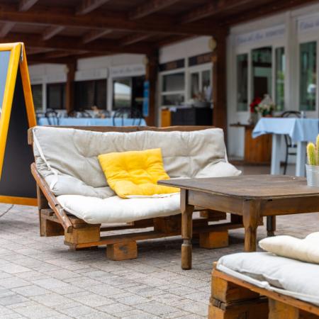 Outdoor seating area with sofas and a wooden table.