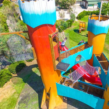 Colorful castle with slides and climbing nets.