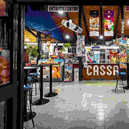 Colorful kiosk with cash register and snacks.